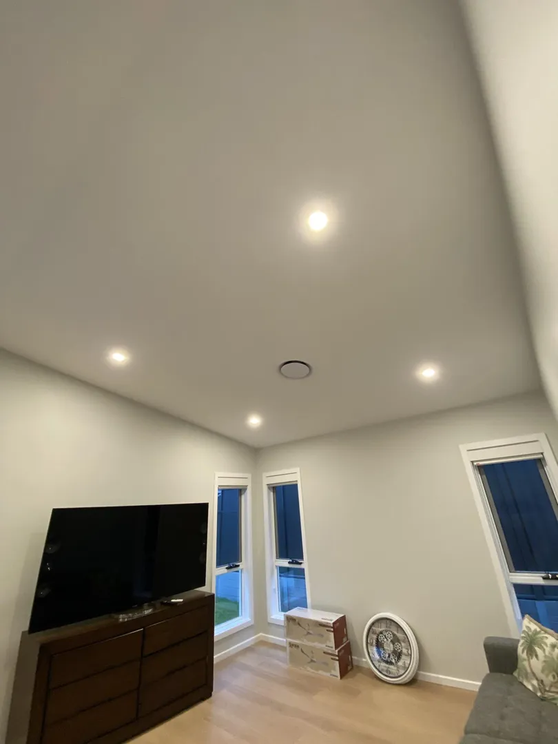 Living room with TV, boxes, and wall clock.